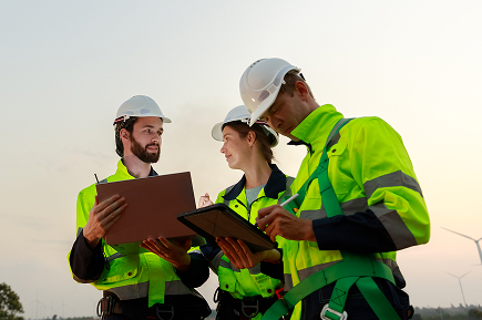 workers with high-vis gear and hardhats conferring